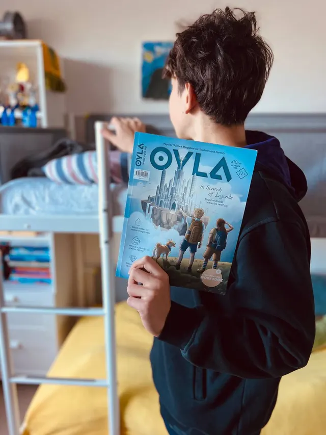 A reader holding a new issue of OYLA in his bedroom.