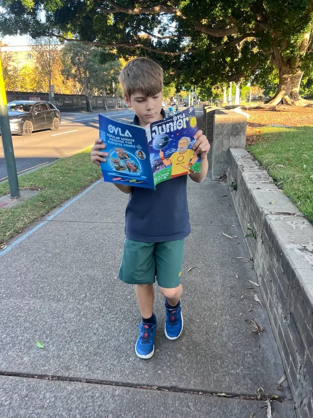 A young reader enjoying OYLA Junior on a walk.