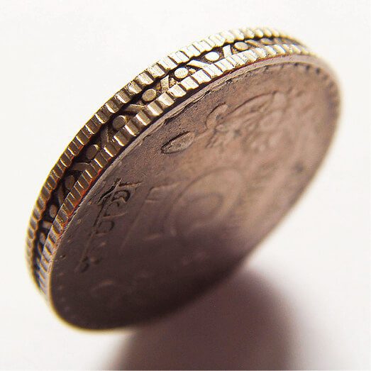 A close up of a coin on a white surface.