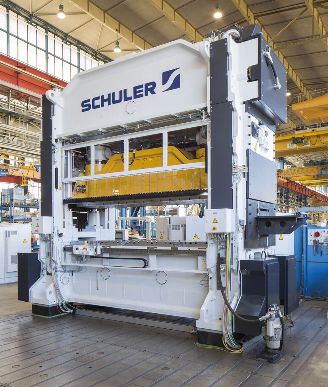 A large machine in a factory with the word scheuler stamped on it.