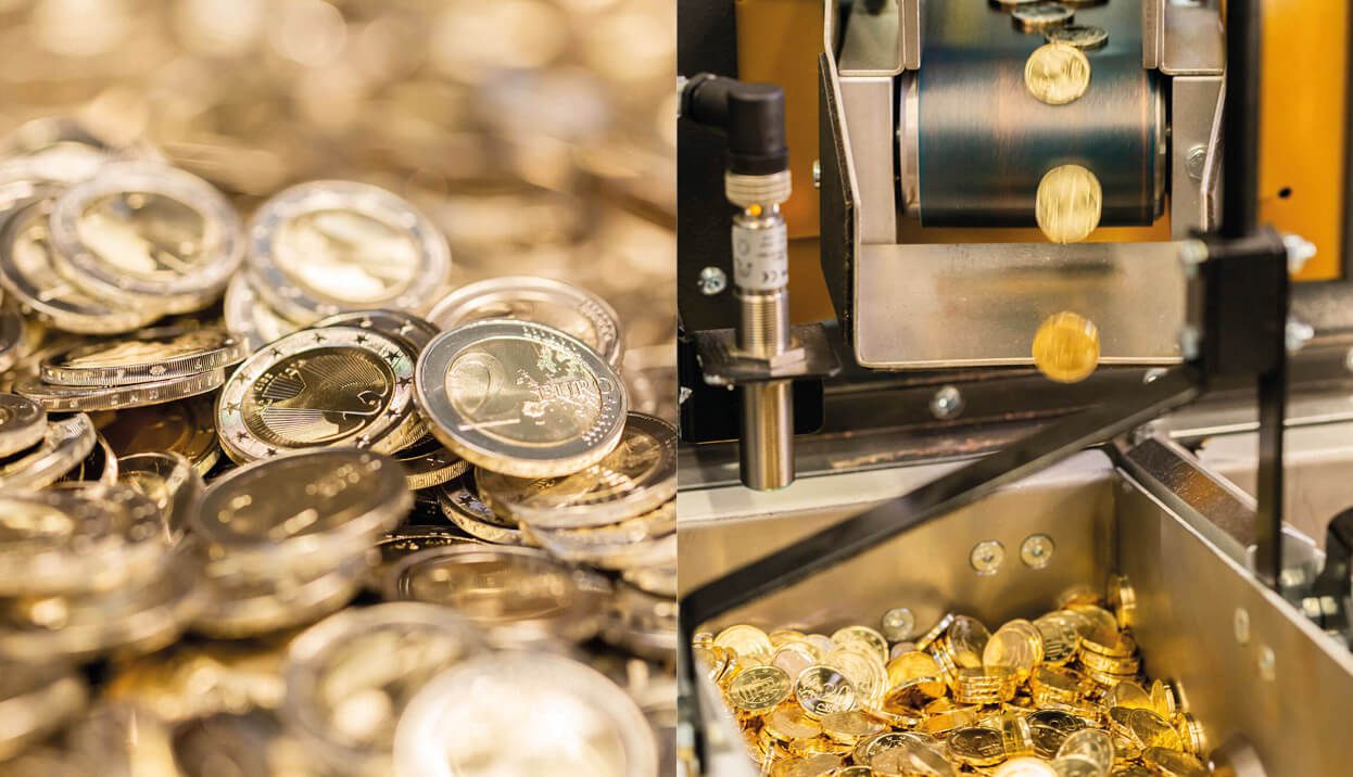 A machine is making silver coins in a factory while preserving the history of coins and their value.