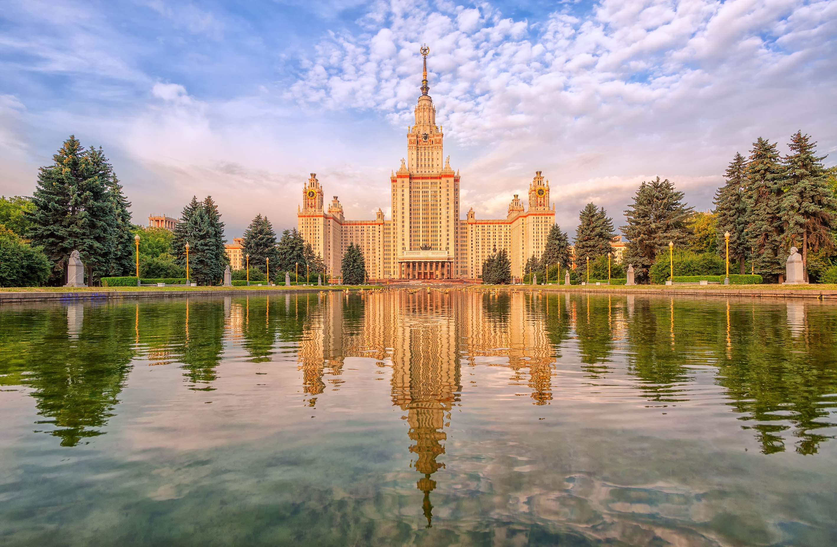A large building is reflected in a pond.