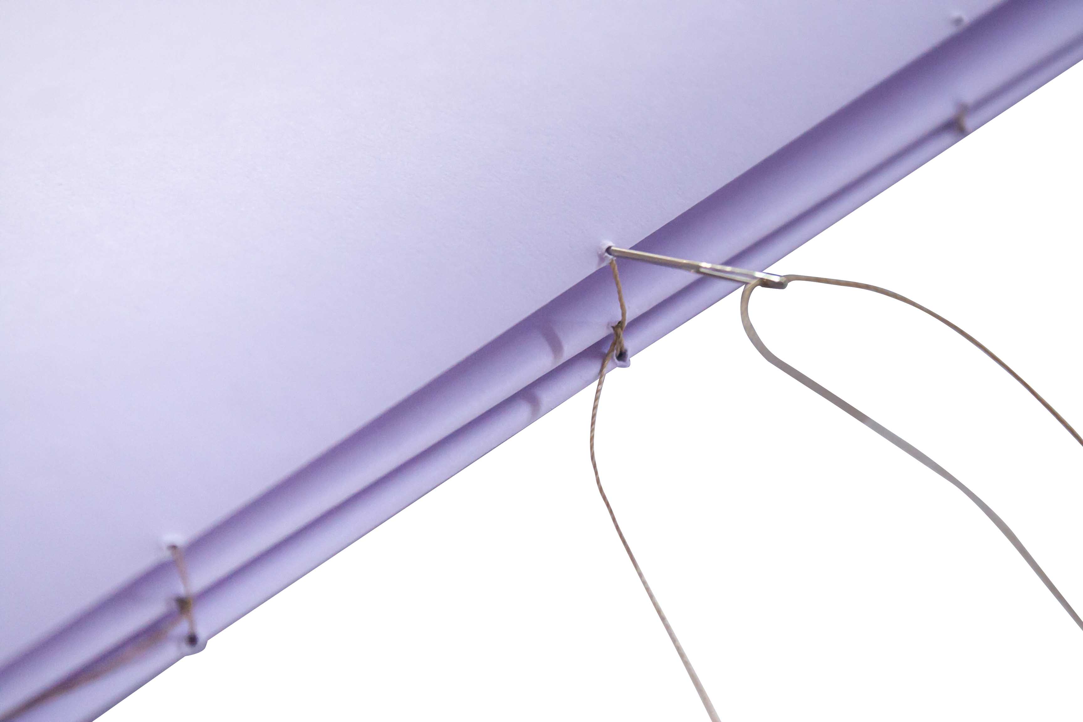 Close-up of a purple kite with string against a white background.