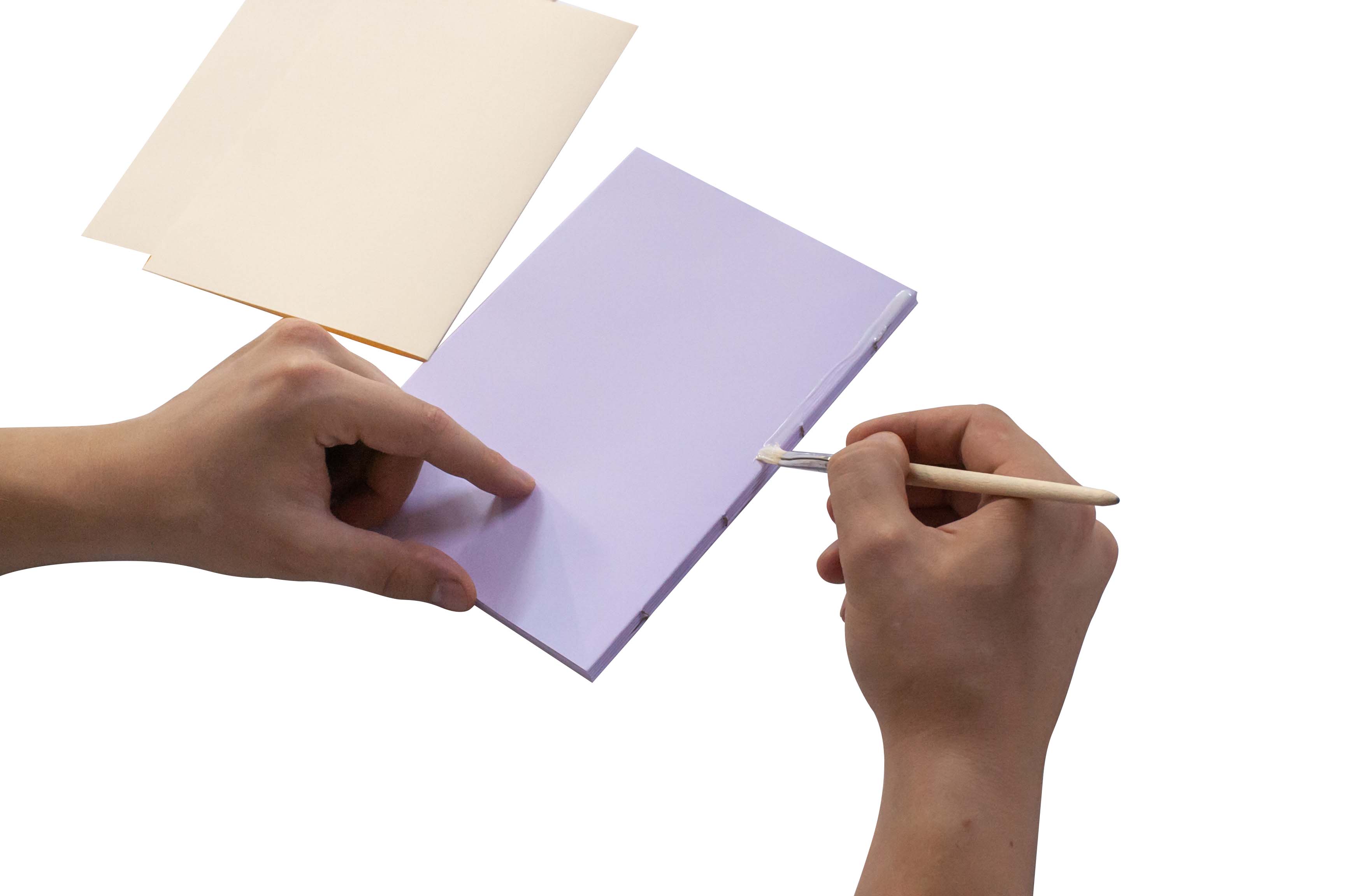 Hands holding a blank purple card and a paintbrush against a white background.