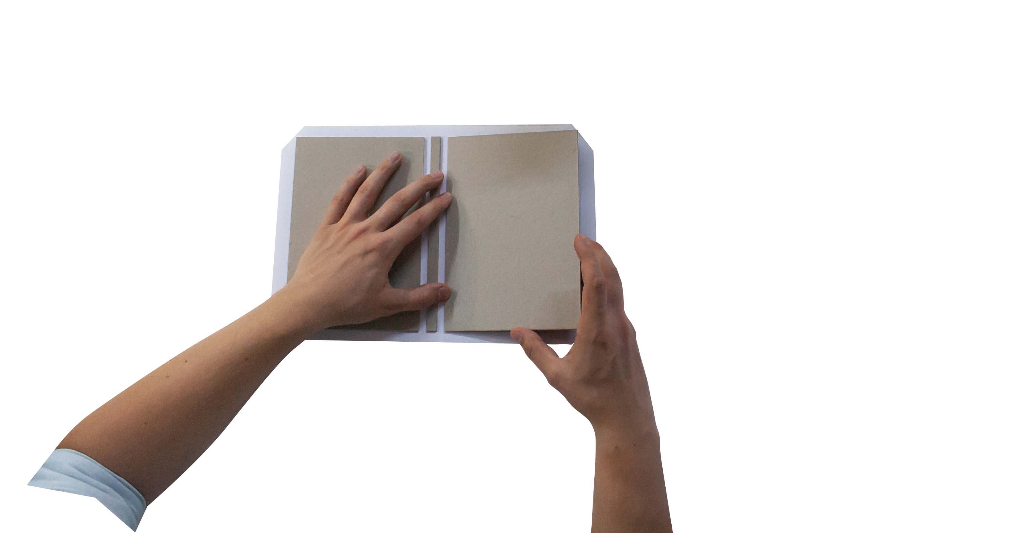 Hands holding an open blank book against a white background.