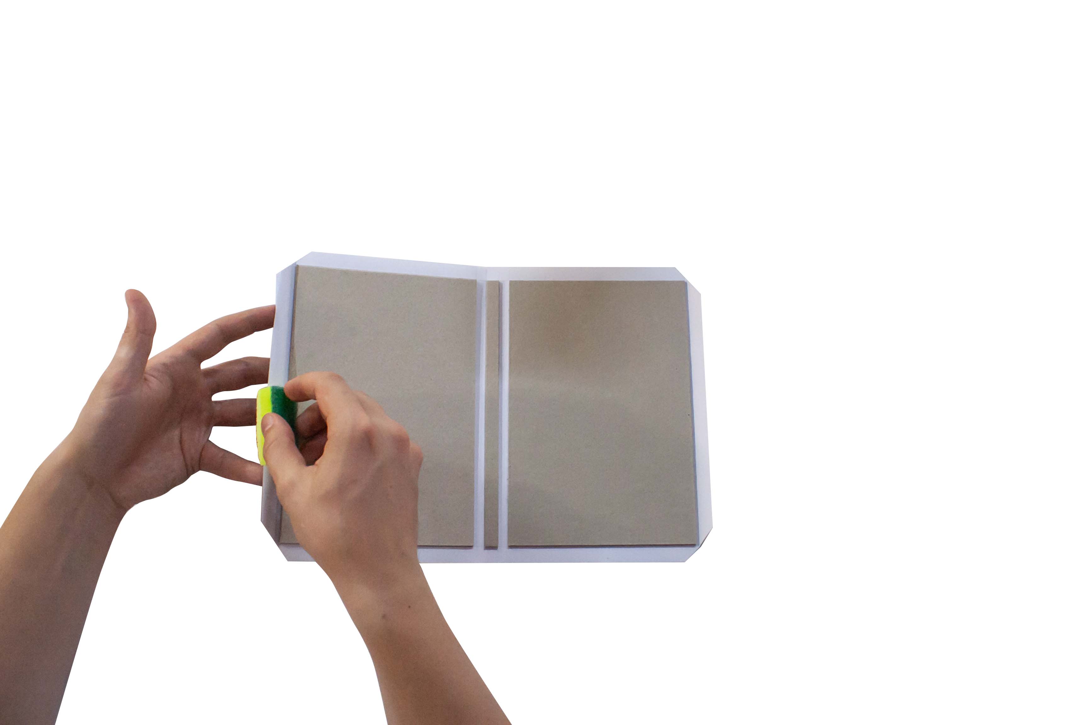 A person opening a blank notebook with a pen in hand, isolated on a white background.