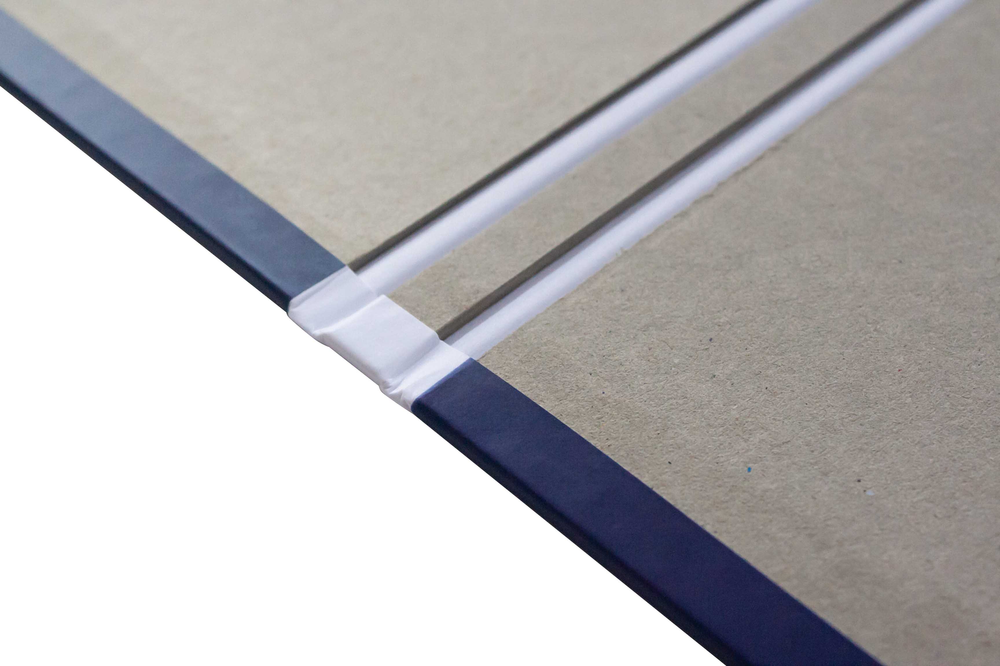 Close-up of a transparent acrylic sheet on top of a cardboard surface with a dark edge binding.