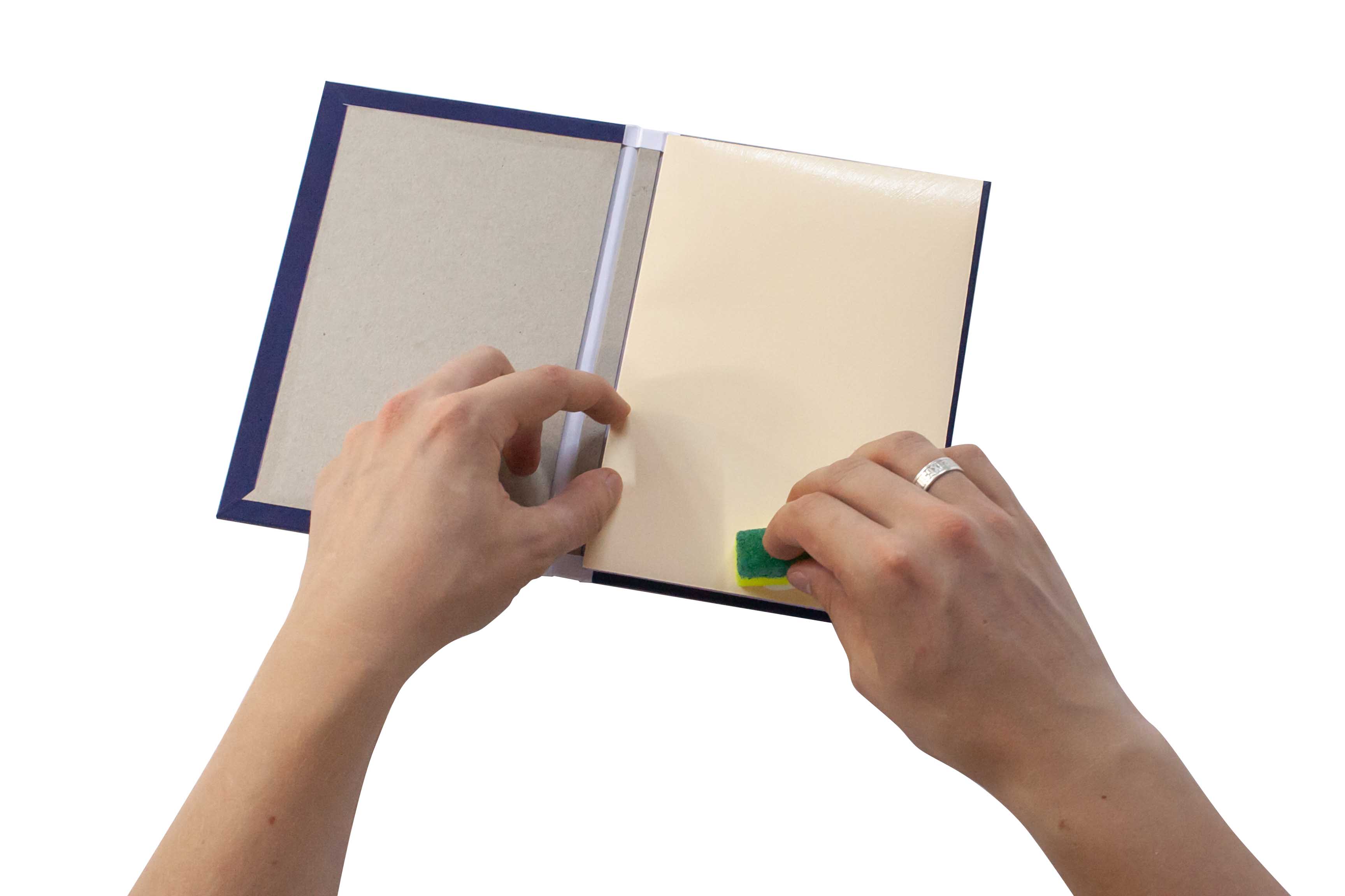 Hands removing a sticky note from a notebook.